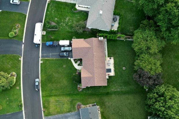 Aerial view of a suburban neighborhood showcasing houses, roads and lush greenery.