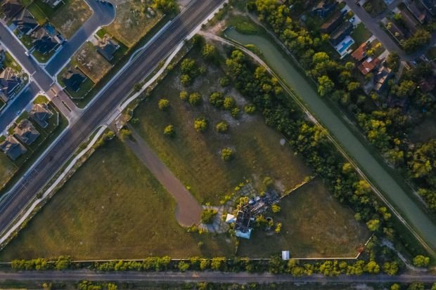 Drone shot showcasing a suburban neighborhood and green fields in Edinburg, Texas.