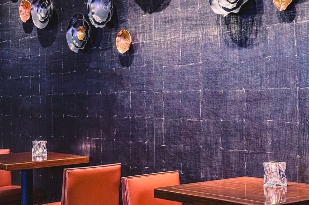 Stylish cafe interior featuring artistic wall decor with vibrant seating and elegant tables.