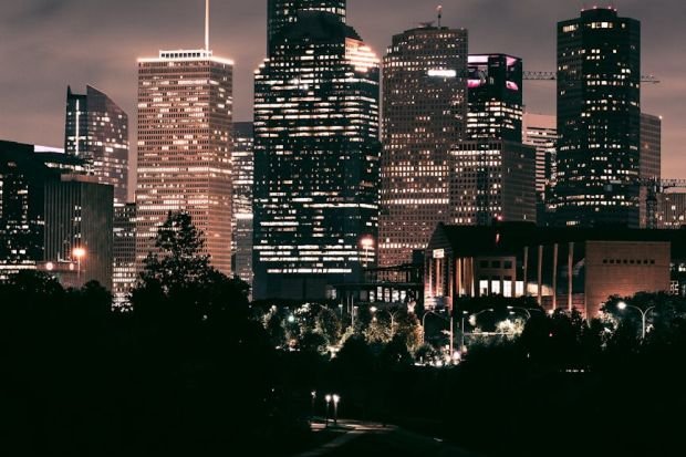 Breathtaking view of Houston's illuminated skyline reflecting on a river at night.