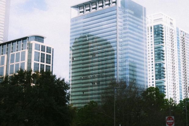 Skyscrapers in downtown Houston under a cloudy sky, showcasing urban architecture.