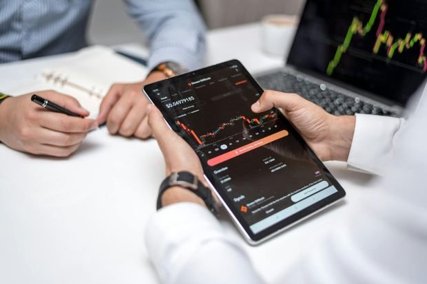Professionals analyzing cryptocurrency data on a digital tablet during a business meeting.